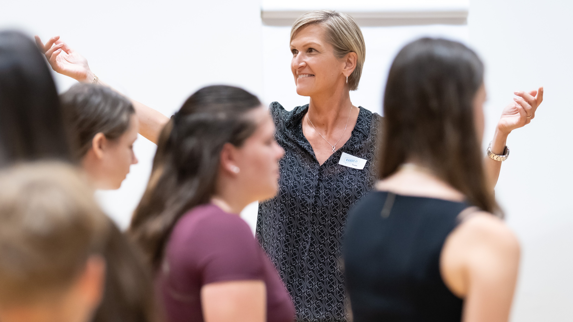 eine Trainerin währed Workshops, im Vordergrund 3 Schüler:innen von hinten